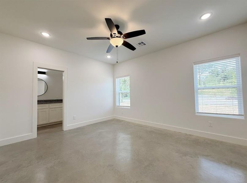 Unfurnished bedroom featuring concrete flooring, recessed lighting, ceiling fan, and connected bathroom Unfurnished bedroom featuring concrete flooring, recessed lighting, ceiling fan, and connected bathroom