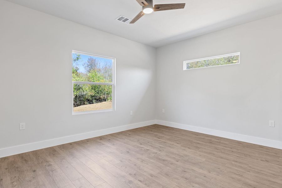 Empty room featuring light wood finished floors and a ceiling fan