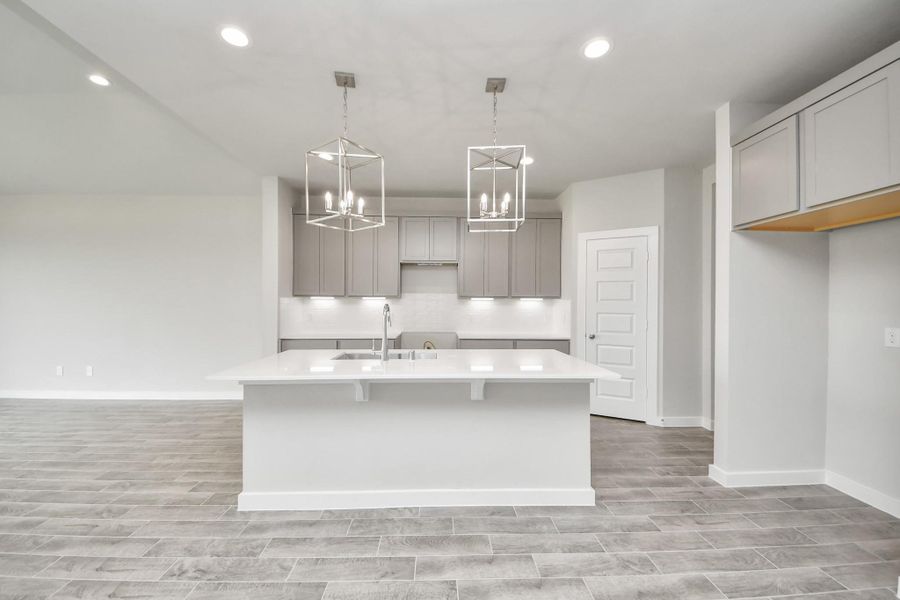 This kitchen is by far any chef’s dream! This spacious kitchen features high ceilings, light stained wood cabinets, granite countertop, SS appliances, modern tile backsplash, recessed lighting, extended counter space, granite kitchen island with double sink, and space for breakfast bar, and a walk-in pantry all overlooking your huge family room. Sample photo of completed home with similar floor plan. Actual colors and selections may vary.