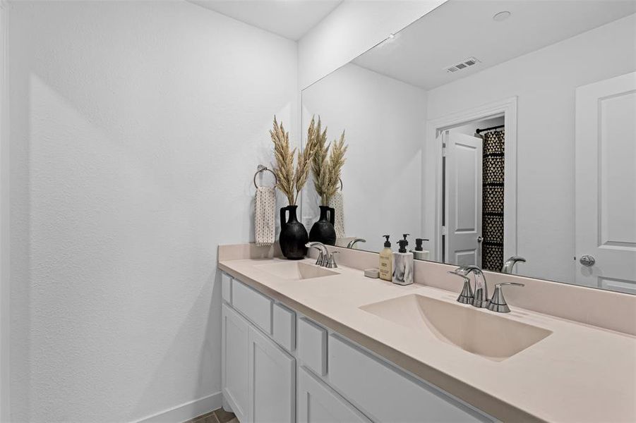 Full bathroom featuring double vanity and baseboards
