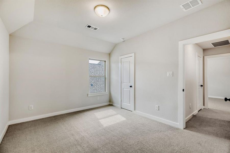 Unfurnished bedroom with lofted ceiling and carpet