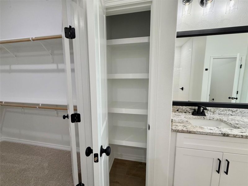 Bathroom vanity with granite-style countertop, undermount sink, and matte black faucet