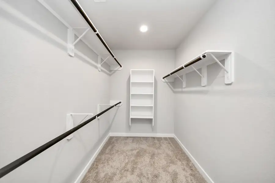 Walk-in closet that epitomizes luxury and practicality. This generously sized space features built-in shelving, offering abundant room for impeccable organization. High ceilings and recessed lighting create a bright and welcoming ambiance. Sample photo of completed home with similar floor plan. Actual colors and selections may vary. Walk-in closet that epitomizes luxury and practicality. This generously sized space features built-in shelving, offering abundant room for impeccable organization. High ceilings and recessed lighting create a bright and welcoming ambiance. Sample photo of completed home with similar floor plan. Actual colors and selections may vary.