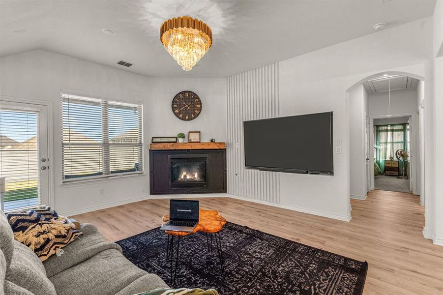 Living room featuring light wood-type flooring, vaulted ceiling, and plenty of natural light