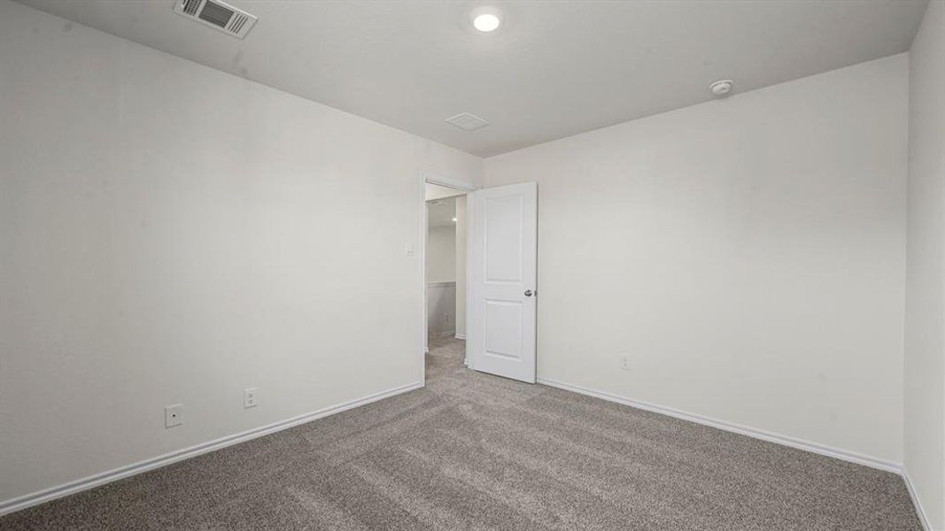 Spacious room with light gray carpeting and white walls