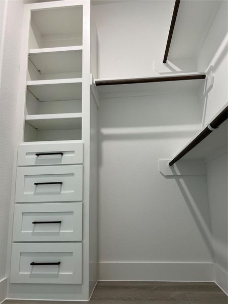 Hers closet with cabinets and shelfs