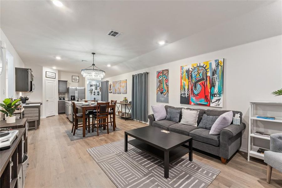 Living area with light wood-style flooring, a chandelier, and recessed lighting