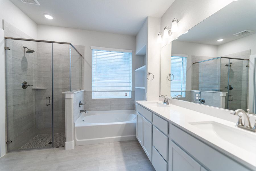 Bathroom with double vanity, a shower stall, and a bath