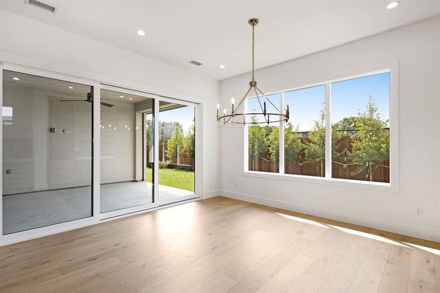 Unfurnished dining area with an inviting chandelier and hardwood / wood-style floors