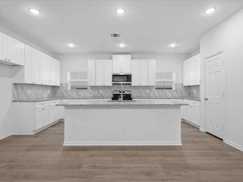 At the center of the home, the kitchen blends style and practicality with granite surfaces, expansive center island, stainless appliances, soft-close cabinetry, and abundant storage. At the center of the home, the kitchen blends style and practicality with granite surfaces, expansive center island, stainless appliances, soft-close cabinetry, and abundant storage.