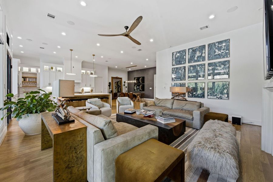 Alternate view of the living space showcasing the open-concept design and effortless flow into the chef’s kitchen. Features include wide-plank hardwood flooring, recessed lighting, and thoughtfully curated finishes throughout.
