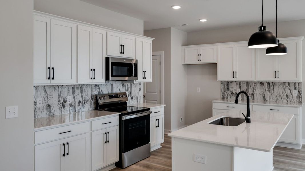 Kitchen with white accents and hanging lights over island
