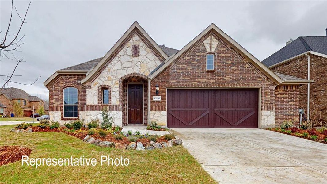 View of front facade featuring a front yard and a garage