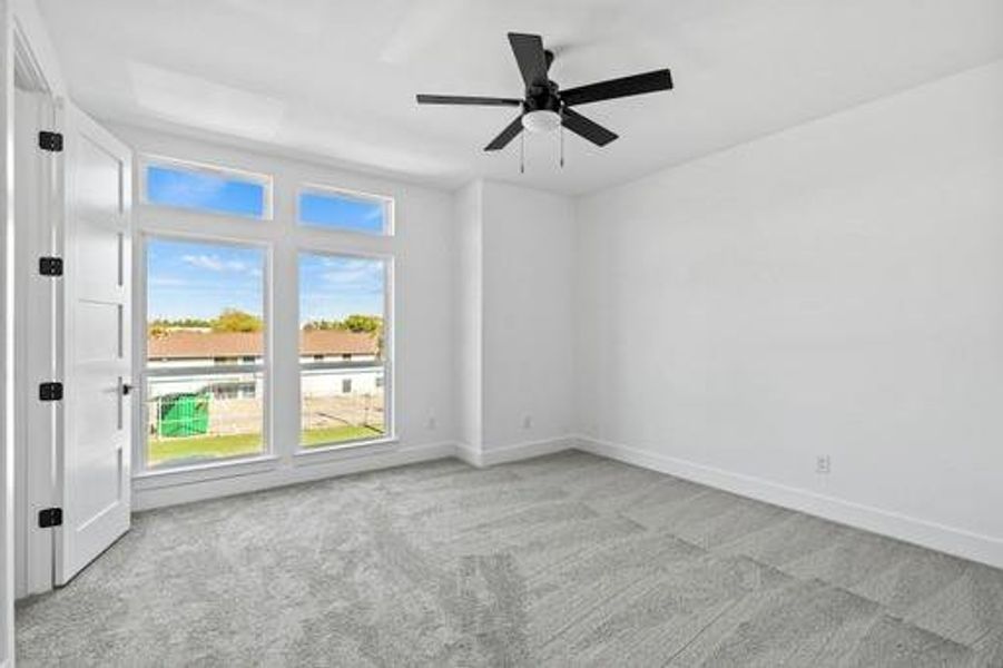 Unfurnished room with ceiling fan and light colored carpet