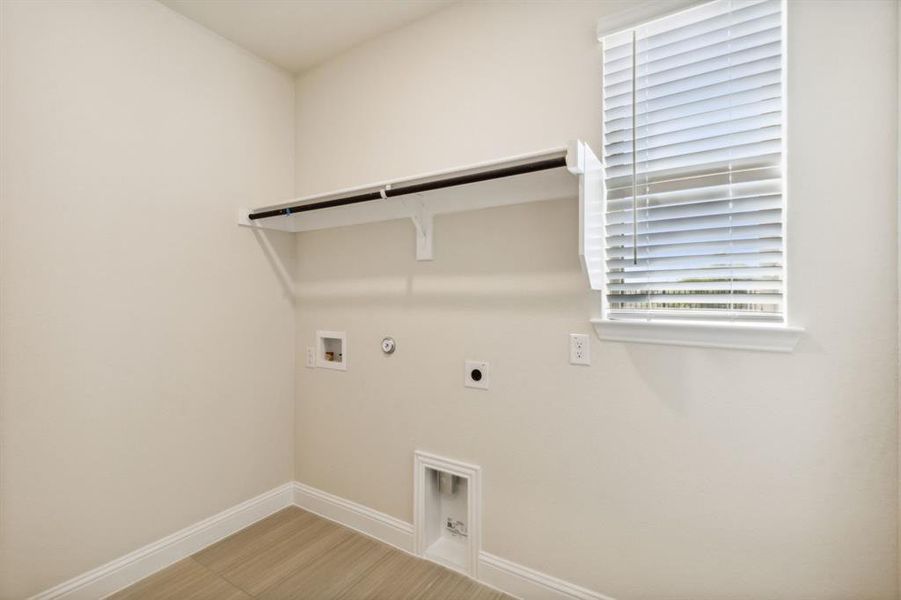 Clothes washing area featuring gas dryer hookup, hookup for a washing machine, plenty of natural light, and electric dryer hookup