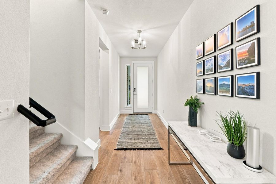 Welcoming foyer featuring upgraded 8-foot interior doors, square sheetrock corners, and sleek black handrail leading upstairs. Welcoming foyer featuring upgraded 8-foot interior doors, square sheetrock corners, and sleek black handrail leading upstairs.
