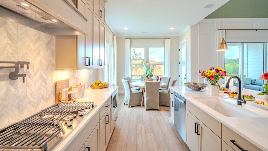 Kitchen with tile backsplash, quartz countertops, and pendant lighting Kitchen with tile backsplash, quartz countertops, and pendant lighting