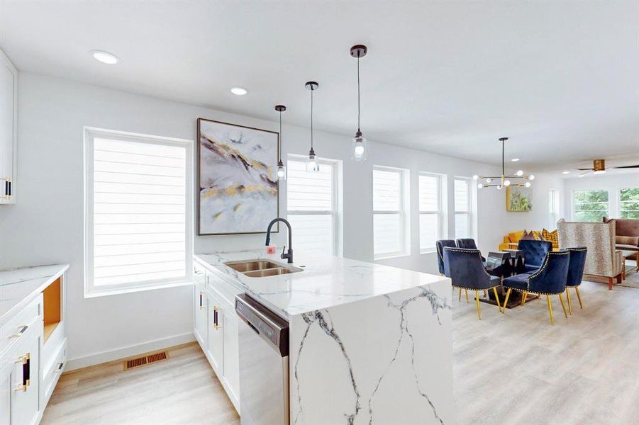 Kitchen with dishwasher, pendant lighting, sink, and white cabinets