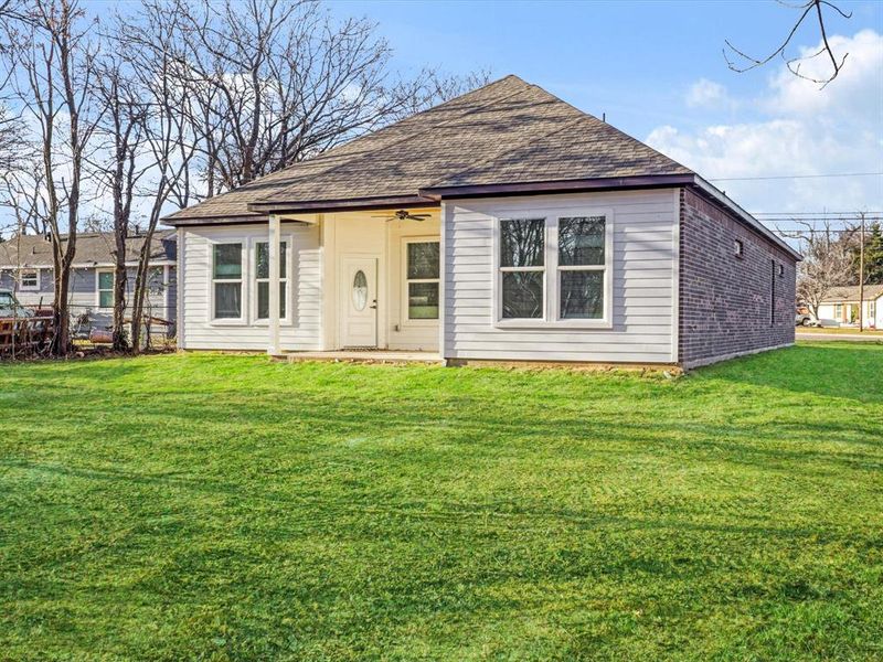View of front of home featuring a shingled roof and a front lawn View of front of home featuring a shingled roof and a front lawn