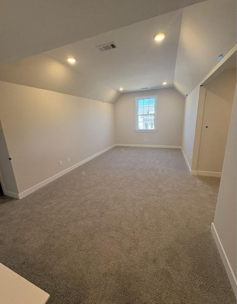 Additional living space with light colored carpet and recessed lighting