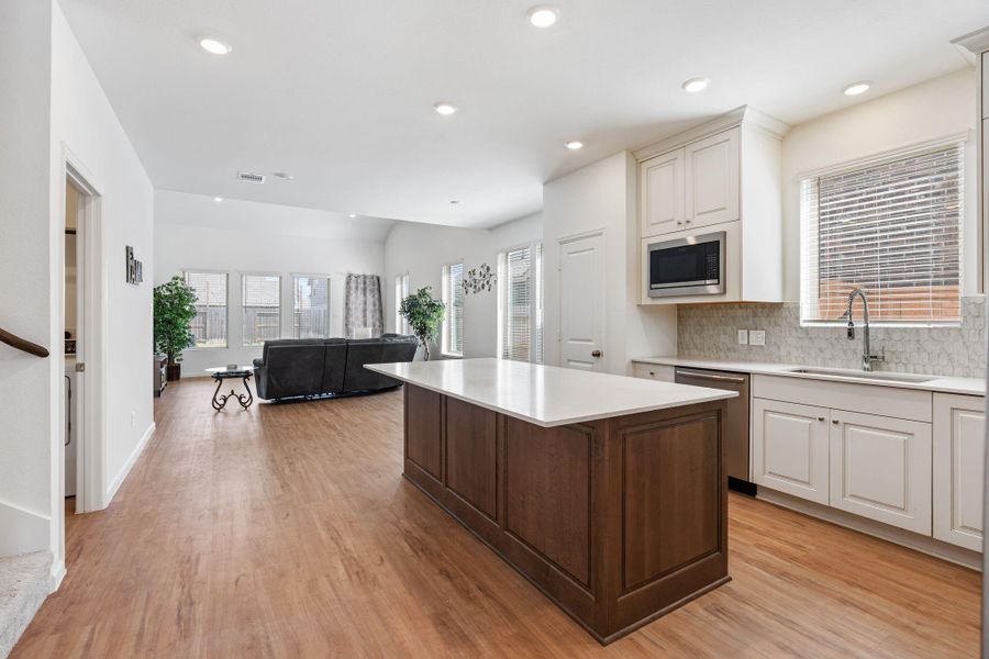 The kitchen is open to a large living area showcasing a wall of windows that lets in tons of natural light!