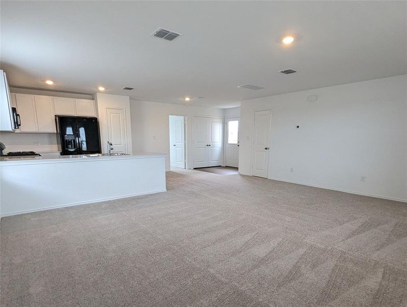 An open floorplan seamlessly connects the well-appointed kitchen with the main living area, featuring recessed lighting throughout.