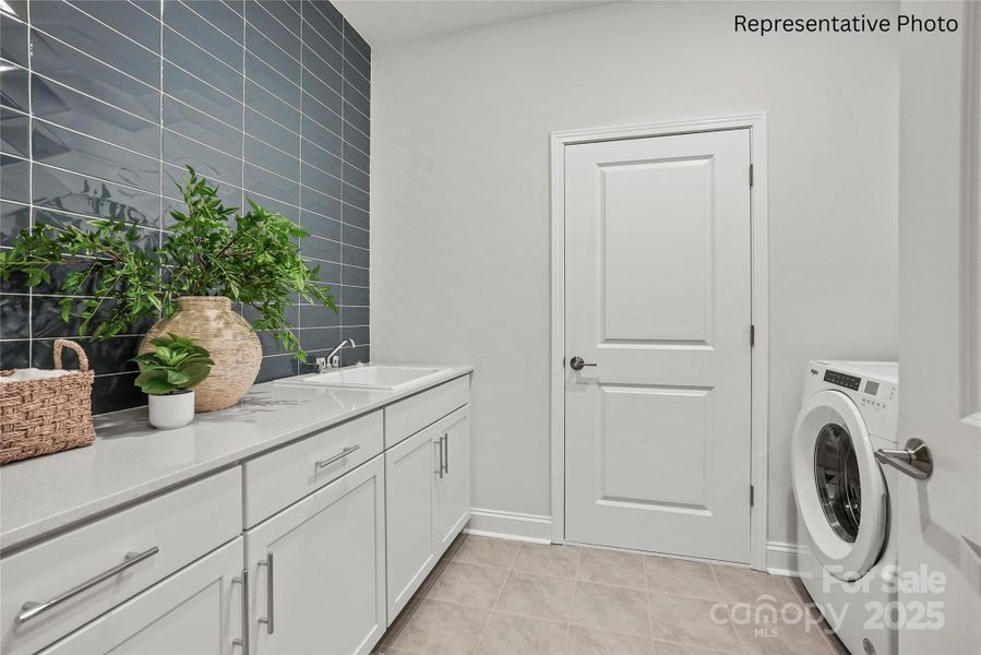 Large laundry room conveniently located off the garage, with cabinets and sink Large laundry room conveniently located off the garage, with cabinets and sink