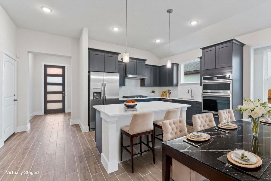 An open concept kitchen features stainless steel appliances and an inviting breakfast bar.