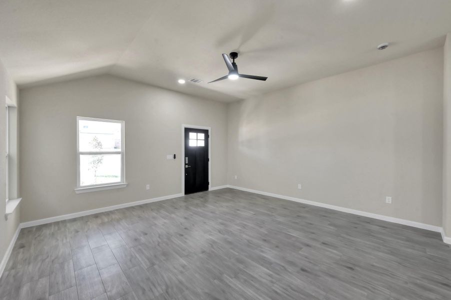 A welcoming first impression: The stylish black-trimmed front door opens into a bright, versatile living area with neutral tones and modern recessed lighting.