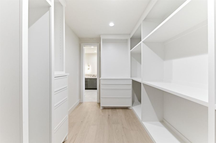 Enjoy boutique-style organization in this expansive walk-in closet featuring ample storage for a beautifully organized lifestyle.
