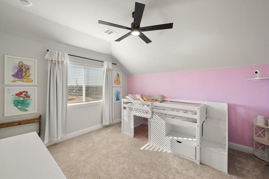 Bedroom featuring light colored carpet, vaulted ceiling, and ceiling fan