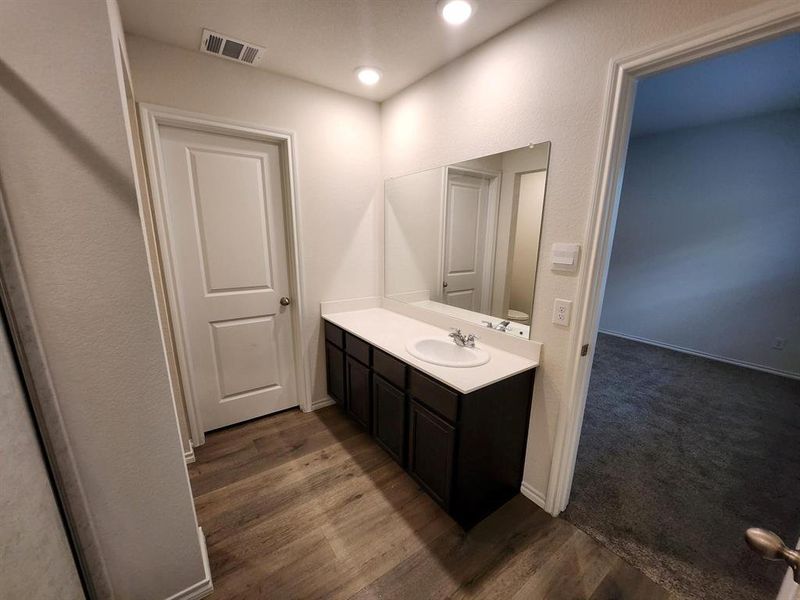 Bathroom with vanity, dark carpet, recessed lighting, and dark wood-style floors