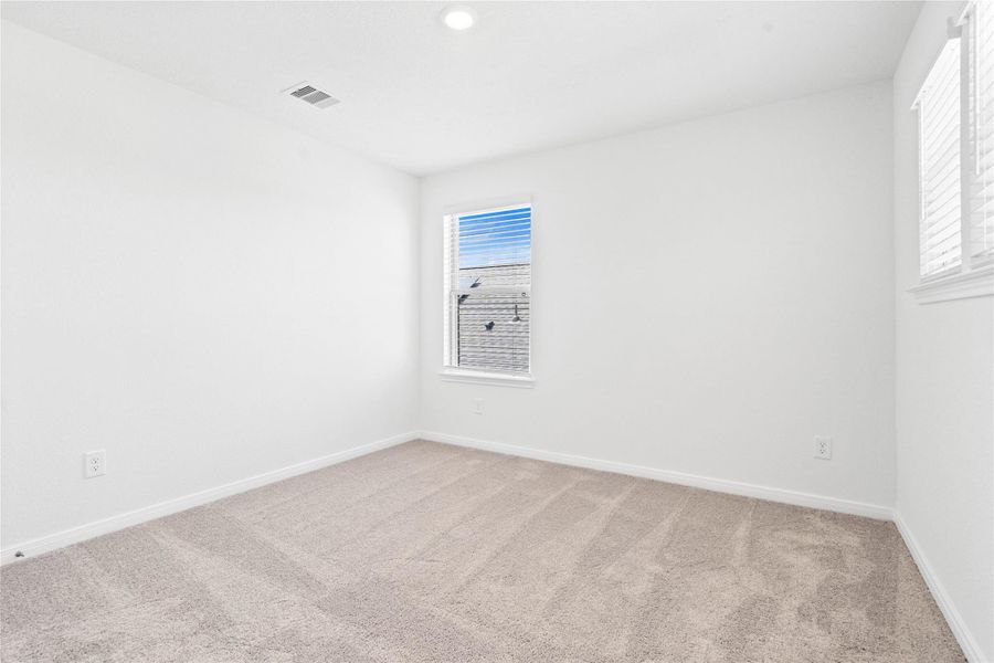 This secondary bedroom offers comfort and style with plush carpeting, neutral paint tones, recessed lighting, windows with blinds, and a generously sized closet. This secondary bedroom offers comfort and style with plush carpeting, neutral paint tones, recessed lighting, windows with blinds, and a generously sized closet.