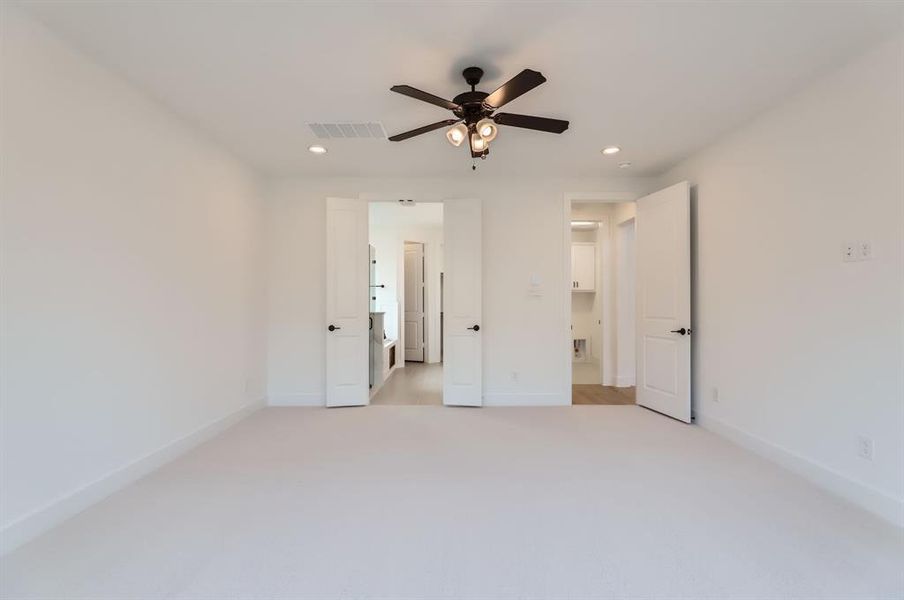 Unfurnished bedroom featuring light carpet and ceiling fan