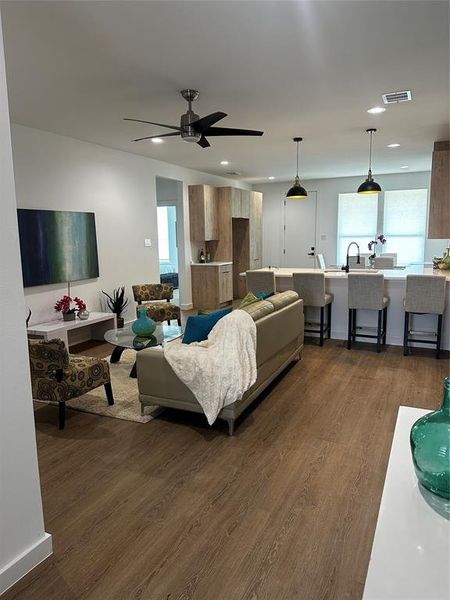 Living room with dark hardwood / wood-style flooring and ceiling fan