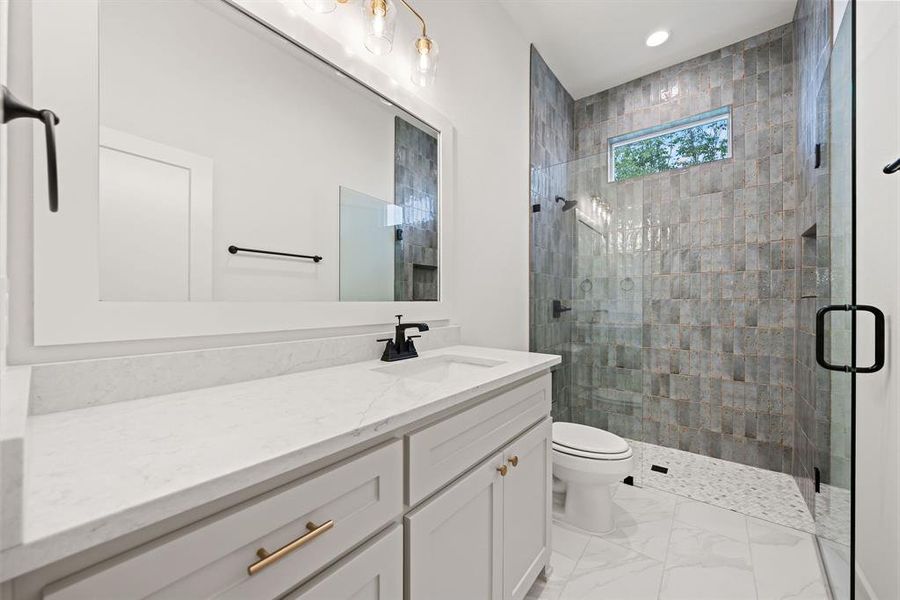 Bathroom featuring vanity, a shower stall, and light marble finish floors Bathroom featuring vanity, a shower stall, and light marble finish floors