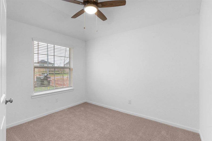 Carpeted spare room featuring baseboards and ceiling fan Carpeted spare room featuring baseboards and ceiling fan