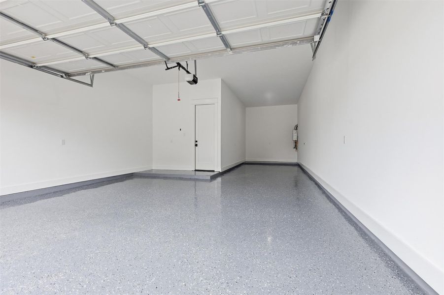 The three-car tandem garage is finished with epoxy flooring, a motorized door, and EV-ready connections, thoughtfully designed to support a modern lifestyle.