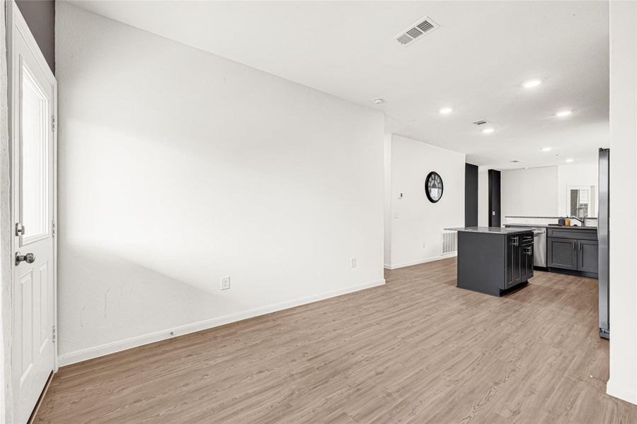 Alternate angle of the open living space highlighting the expansive floor plan and modern recessed lighting.