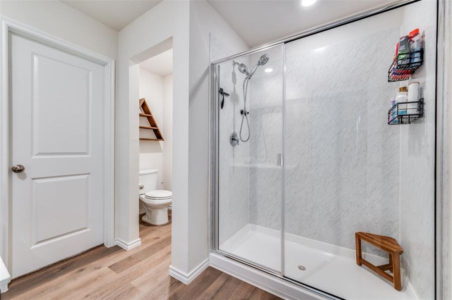 Bathroom featuring light wood finished floors and a stall shower