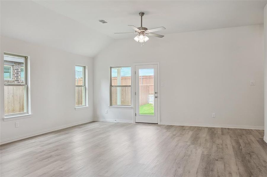 Spare room featuring ceiling fan, light hardwood / wood-style flooring, and vaulted ceiling