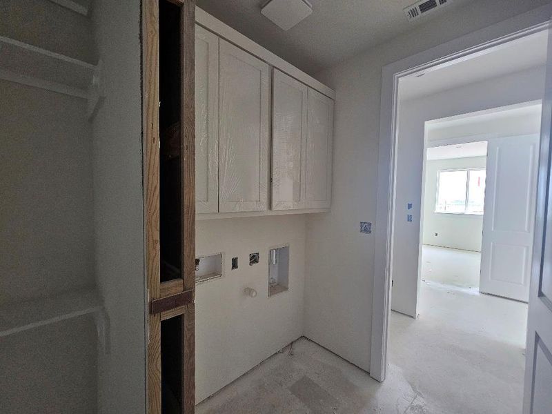 Washroom featuring cabinet space, hookup for a washing machine, and electric dryer hookup Washroom featuring cabinet space, hookup for a washing machine, and electric dryer hookup