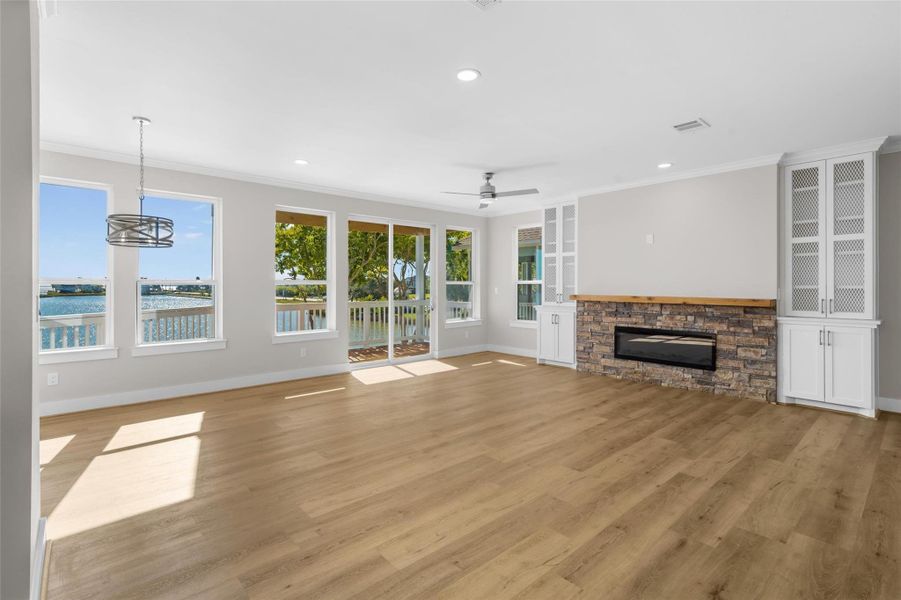 Spacious living room with no detail overlooked! Stone fireplace, designer mantle, built in shelving, a wall of windows and sliding glass doors leading out to a balcony overlooking the water! Spacious living room with no detail overlooked! Stone fireplace, designer mantle, built in shelving, a wall of windows and sliding glass doors leading out to a balcony overlooking the water!