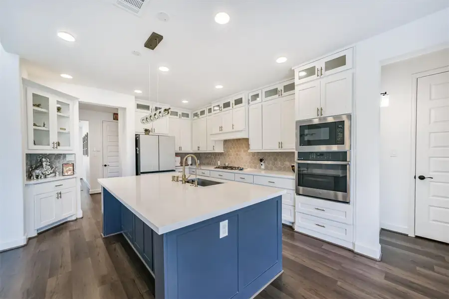 A central island paired with butler pantry and display cabinets featuring elegant glass panels. A central island paired with butler pantry and display cabinets featuring elegant glass panels.