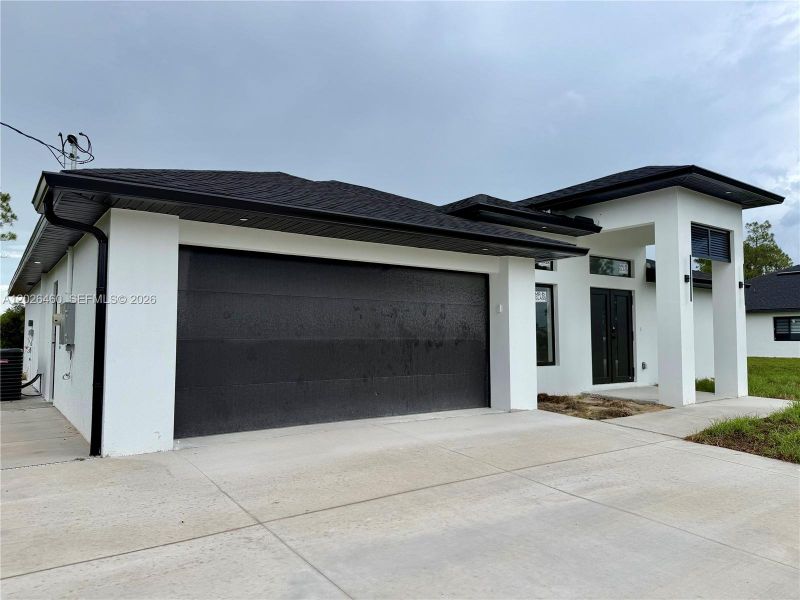 Front exterior of a new home in , Lehigh Acres, FL, highlighting curb appeal (Image 27).