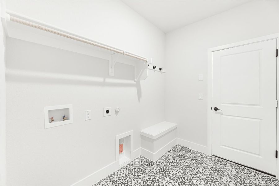Laundry and mudroom with patterned tile floor, built-in bench, wall hooks, and washer and dryer hookups Laundry and mudroom with patterned tile floor, built-in bench, wall hooks, and washer and dryer hookups