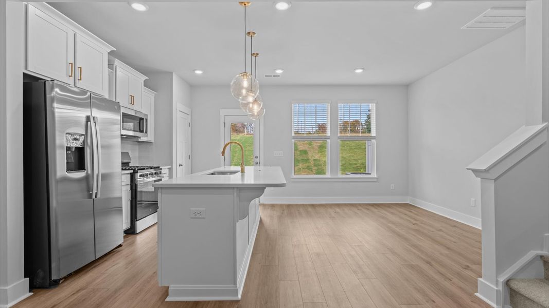 Exceptional kitchen featuring a spacious island, eye-catching pendant lights, and modern finishes Exceptional kitchen featuring a spacious island, eye-catching pendant lights, and modern finishes