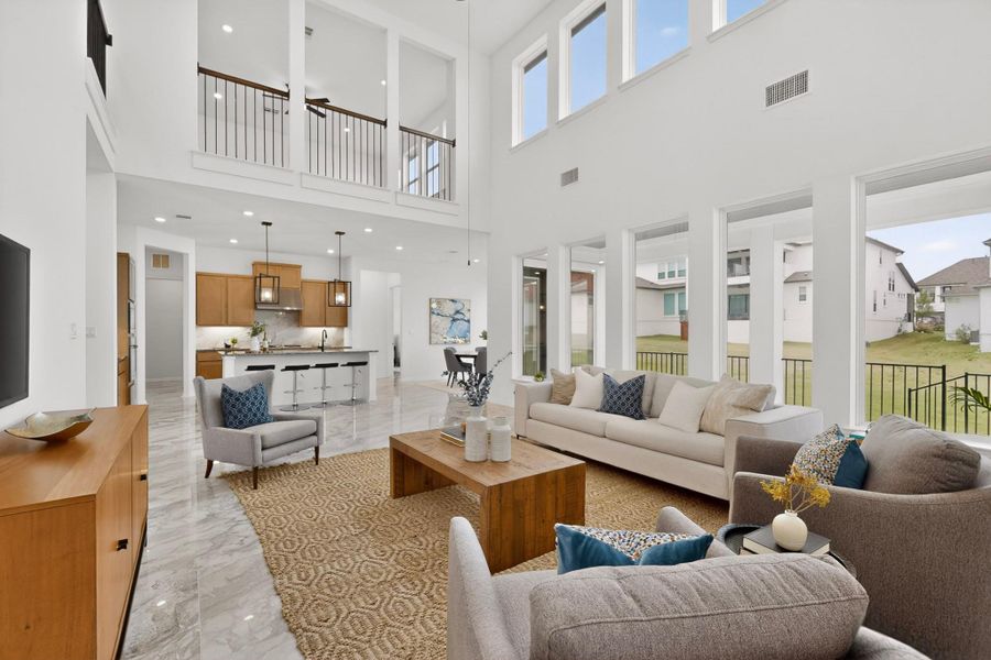 Two-story living area featuring tall ceilings and abundant natural light from upper and lower windows