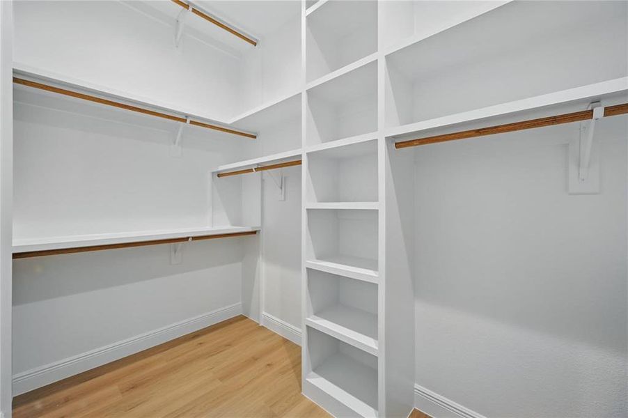 Walk in closet featuring light wood-type flooring Walk in closet featuring light wood-type flooring