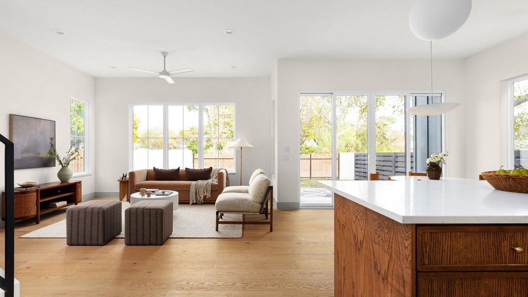 Living area with plenty of natural light, light wood-type flooring, recessed lighting, and a ceiling fan